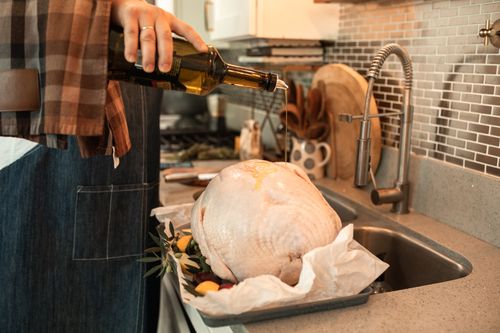 Free A person preparing a turkey for Thanksgiving with olive oil in a kitchen setting. Stock Photo