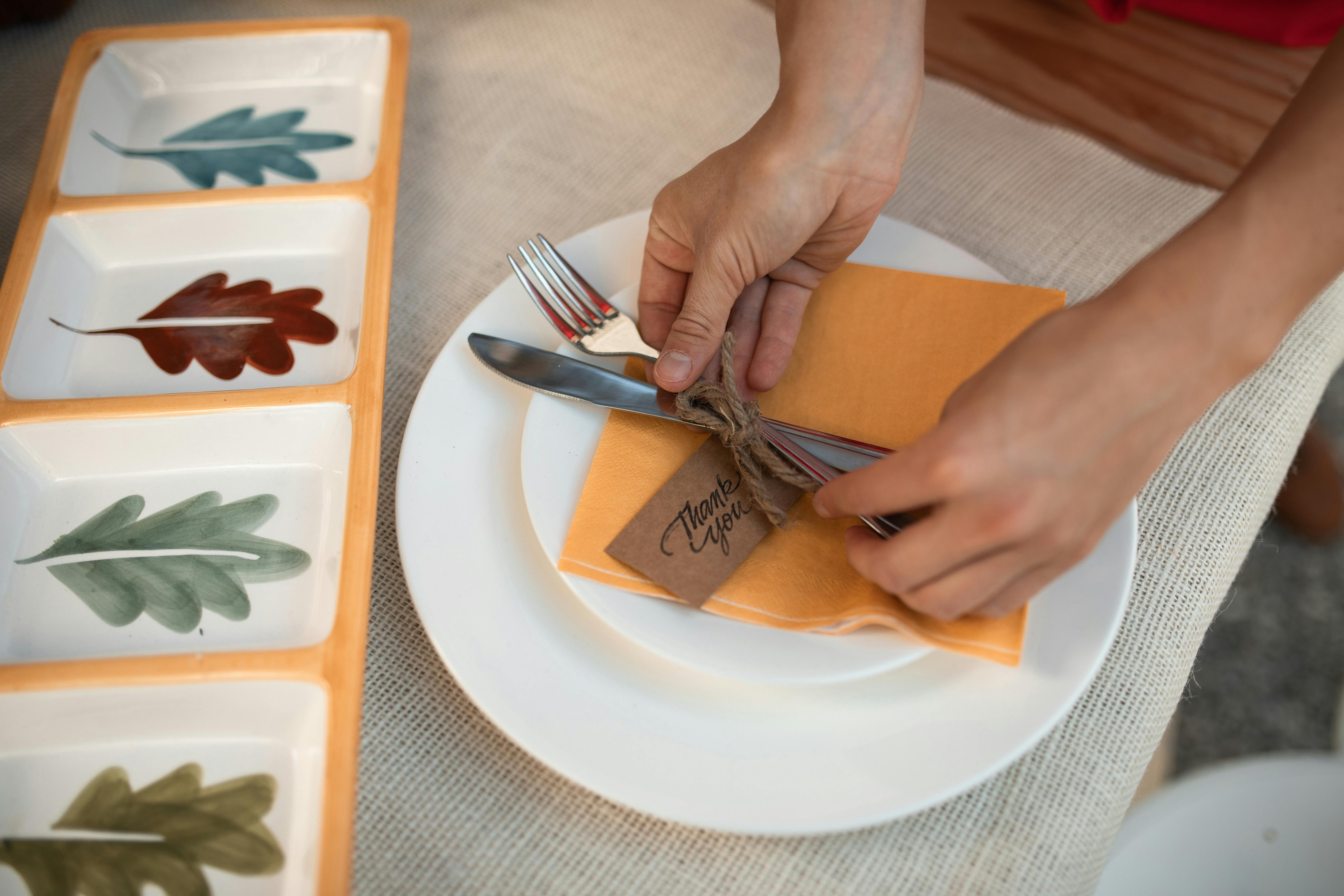 person holding silver fork and bread knife