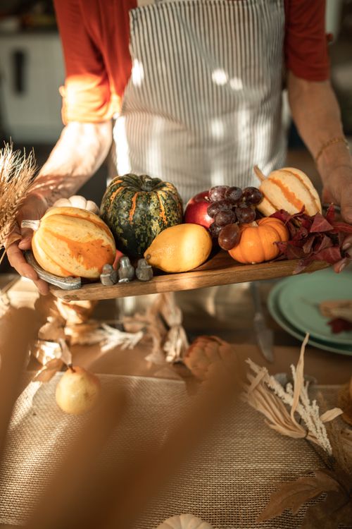 Free A vibrant autumn harvest arrangement with pumpkins and fruits on a wooden tray, perfect for Thanksgiving decor. Stock Photo