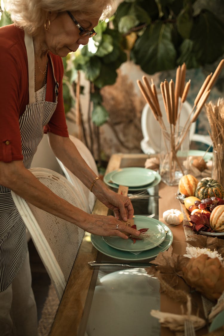 Elderly Woman Setting The Table For Thanksgiving