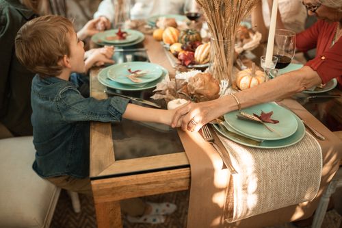 Free Warm family gathering at a beautifully set Thanksgiving dinner table, depicting togetherness and gratitude. Stock Photo