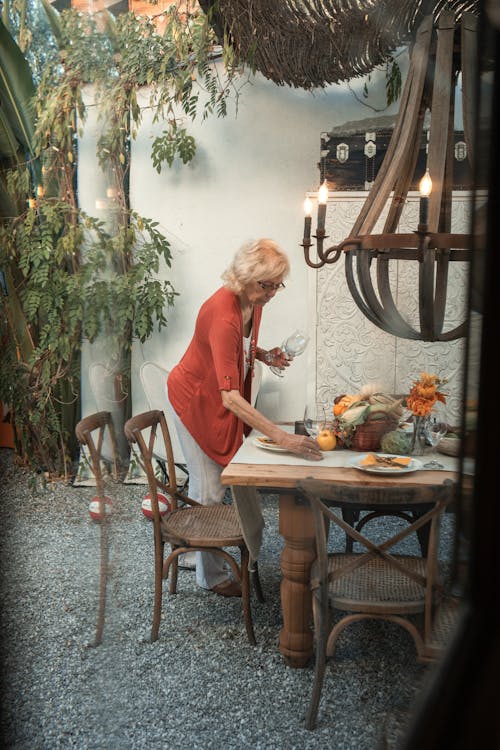 Femme En Chemise à Manches Longues Rouge Debout à Côté D'une Table En Bois Marron