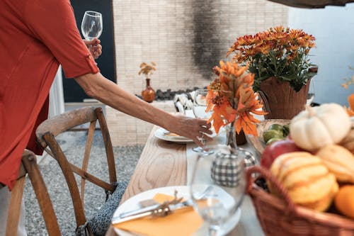 Personne Tenant Un Verre à Vin Clair Près De La Table En Bois Brun