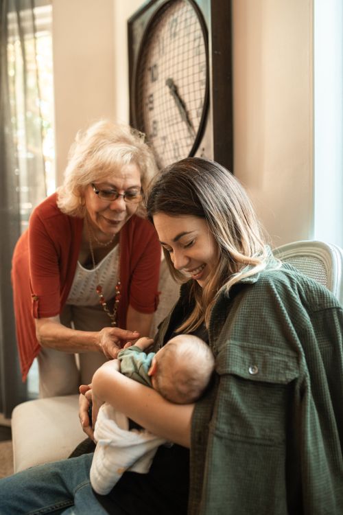 Free A heartwarming indoor scene featuring a mother, grandmother, and baby bonding together. Stock Photo