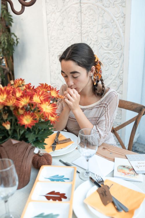 Free A young woman prays before a festive Thanksgiving meal, showcasing gratitude and togetherness. Stock Photo