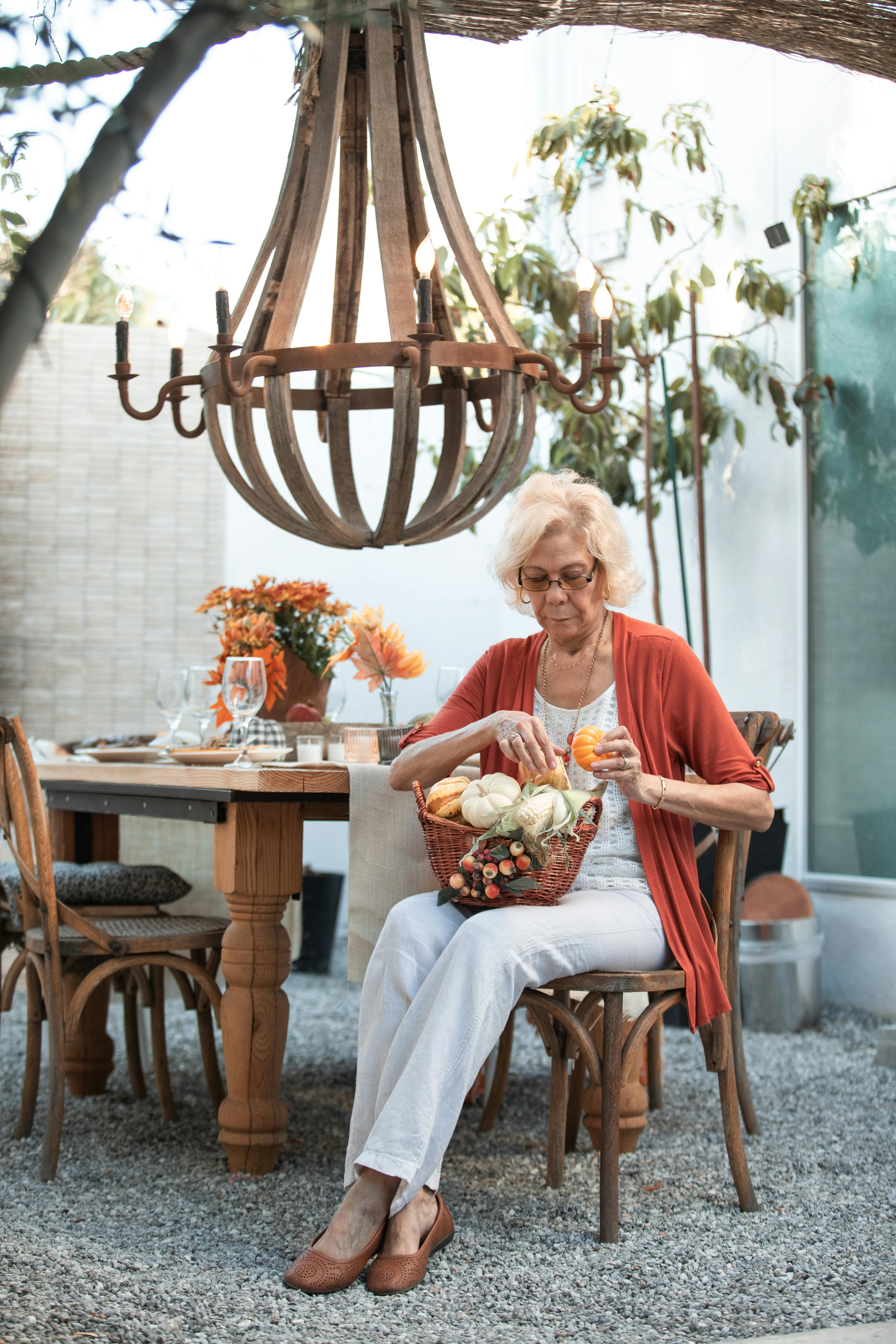 woman in pink shirt sitting on brown wooden chair