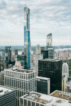 纽约市中心的当代城区，白天多云天空下矗立着高耸的摩天大楼