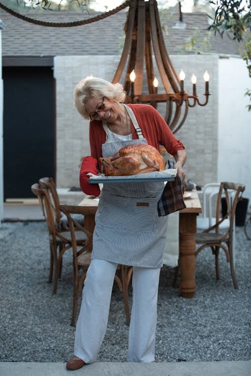 Free Elderly Woman Holding Tray with Roasted Turkey Stock Photo