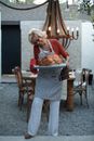 Elderly Woman Holding Tray with Roasted Turkey