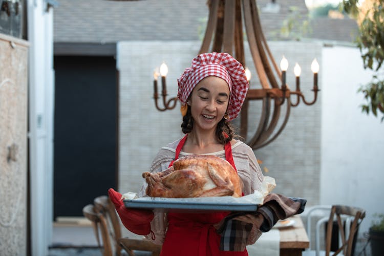 Woman With Chefs Hat Holding Tray With Roasted Turkey