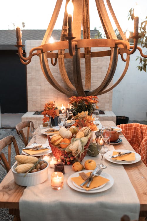 Brown Wooden Chandelier on Top of Wooden Table with Setting