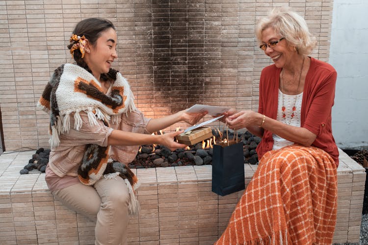 An Elderly Woman Receiving A Gift From A Woman