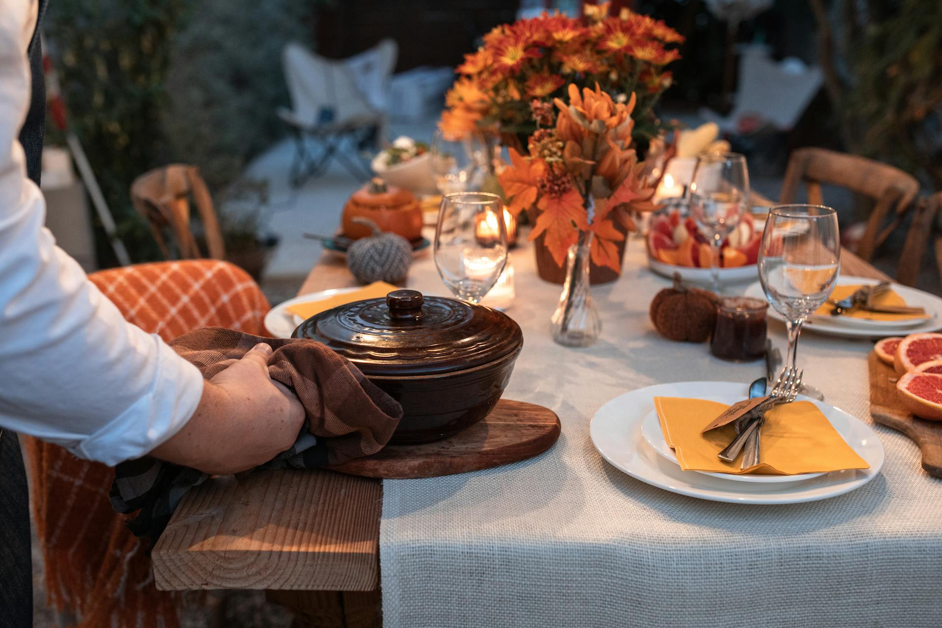 Beautifully arranged autumn table setting with festive decorations and a serving pot.