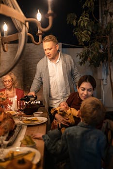 Family enjoying a cozy Thanksgiving dinner with turkey, wine, and candlelight.