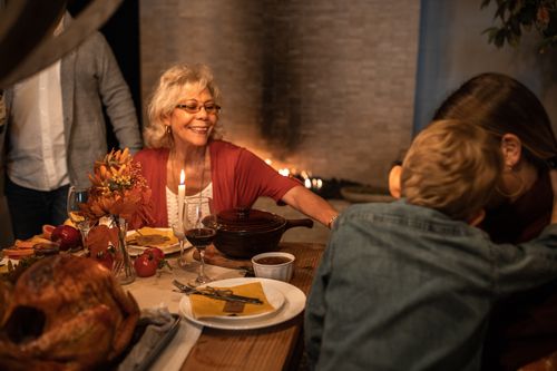Free Joyful family celebration around the Thanksgiving dinner table with delicious food and warm atmosphere. Stock Photo