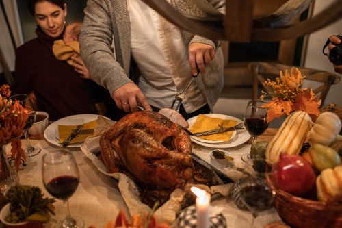 Free A festive Thanksgiving family gathering with carving a roasted turkey and holiday decor. Stock Photo
