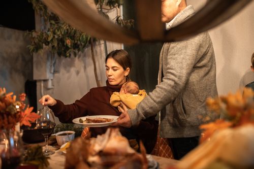 Free Cozy Thanksgiving family dinner scene with autumn decor and heartfelt togetherness. Stock Photo