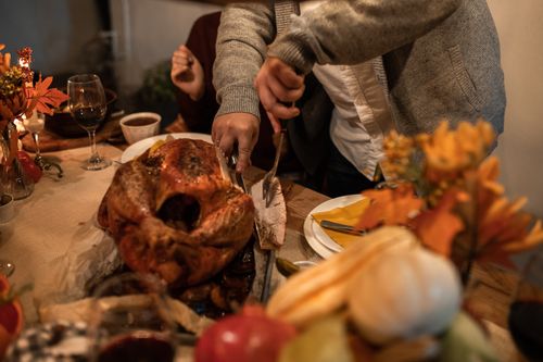 Free A close-up of a festive Thanksgiving table with roasted turkey being carved. Stock Photo