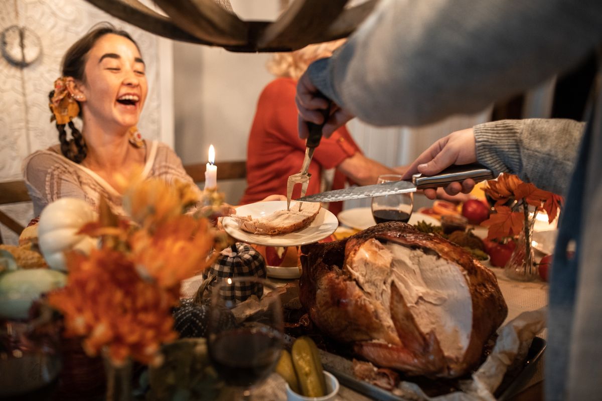 Joyful family gathering around a festive Thanksgiving turkey dinner