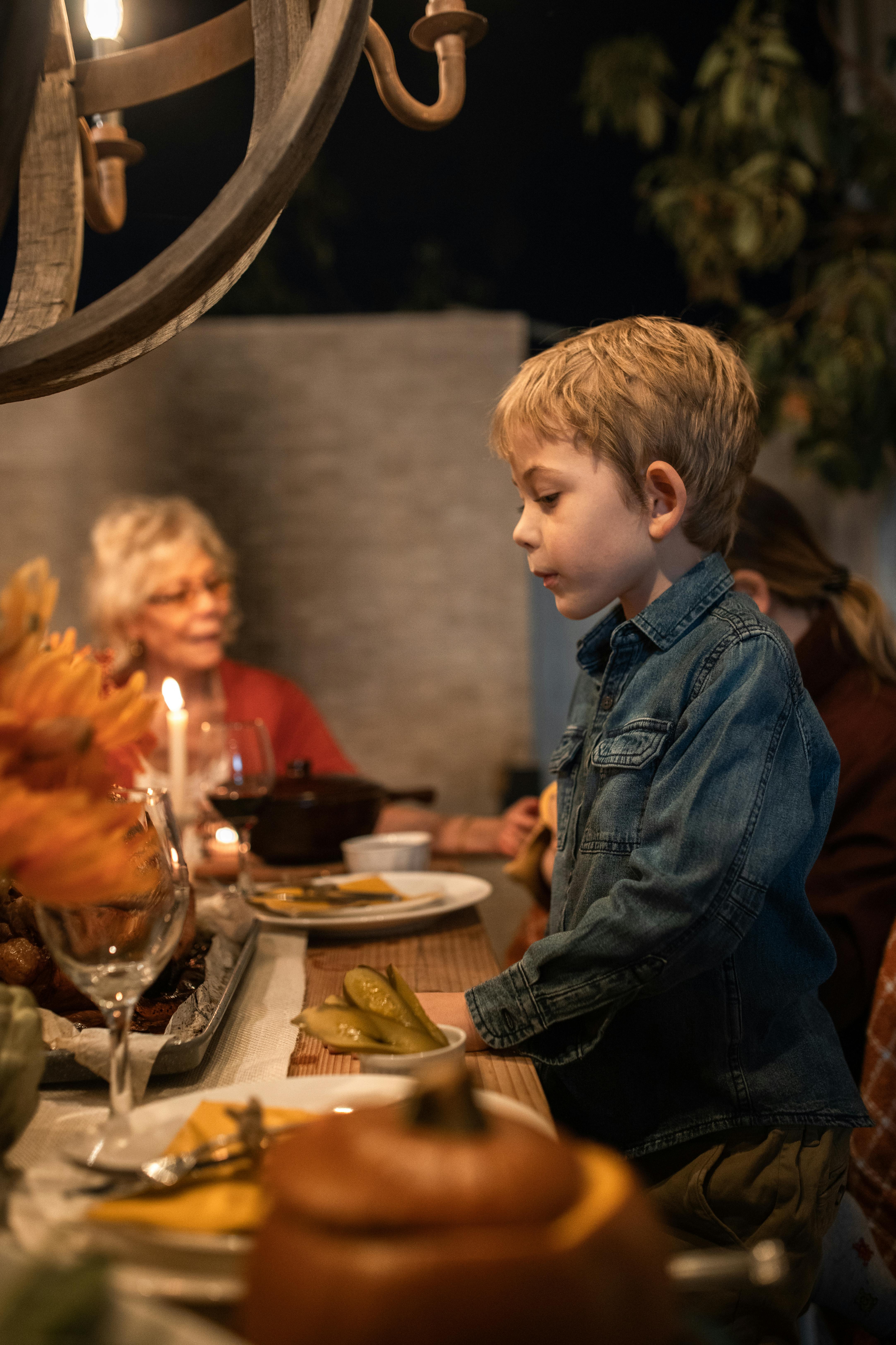 boy in blue denim jacket sitting on chair