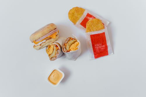 Free A flatlay of a breakfast burrito, hash browns, and dip on a white background. Stock Photo