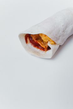 Close-up of a breakfast burrito with eggs and sauce on a white background, perfect for food blogs.