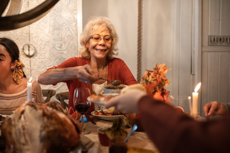 A Elderly Woman Eating At The Table 