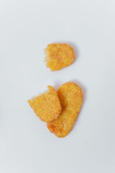 Three golden brown hash browns neatly arranged on a white background, showcasing their crispy texture.