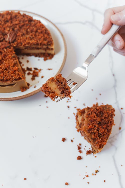 Free Person Holding Pecan Cake on Fork Stock Photo