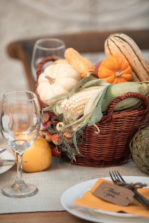 Pumpkins on Brown Woven Basket Beside Clear Wine Glass