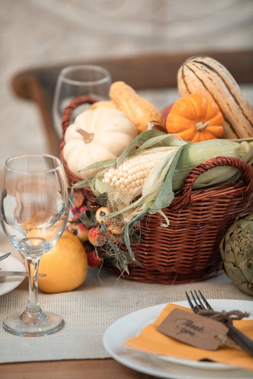 Citrouilles Orange Sur Panier Tissé Marron à Côté De Verre à Vin Clair