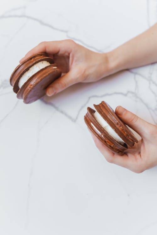 Woman Holding A Chocolate Covered Sandwich Cookies 