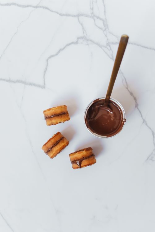 Free Top view of biscuit stacks next to rich chocolate sauce on a marble surface. Stock Photo