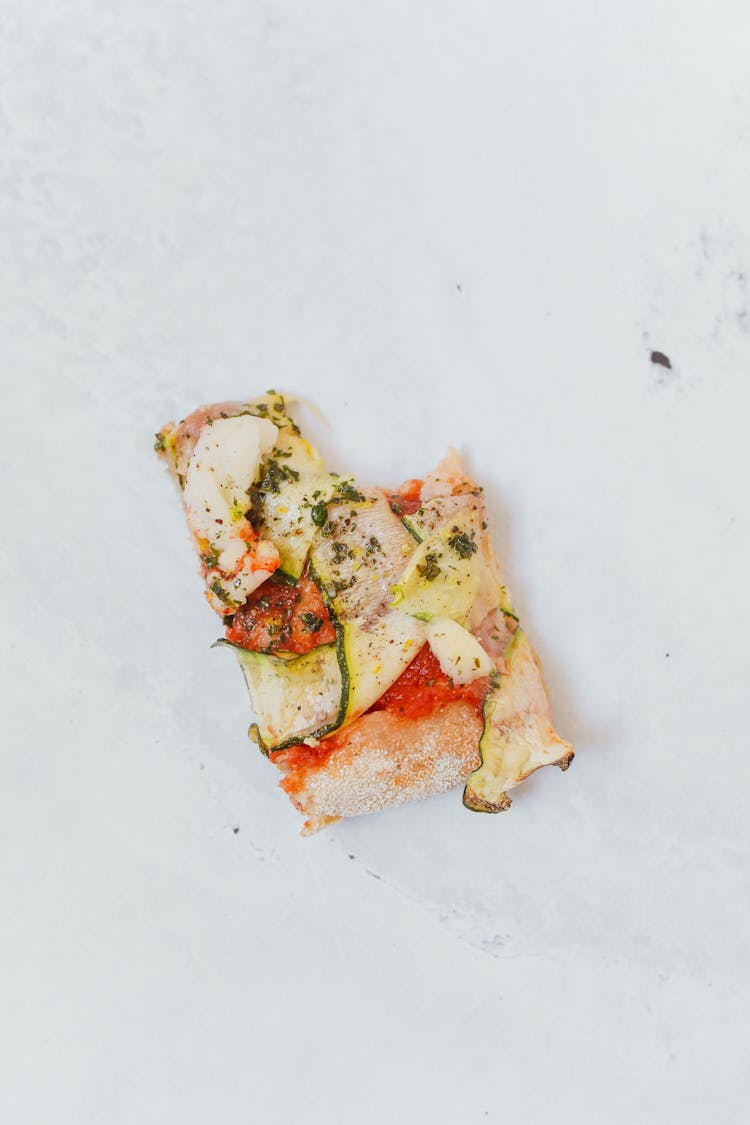 Top View Of A Bitten Slice Of Pizza