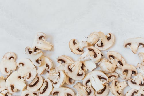White and Brown Sliced Mushrooms on White Surface
