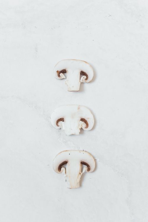 Free Close-up of sliced mushrooms arranged in vertical flat lay on a white surface. Stock Photo