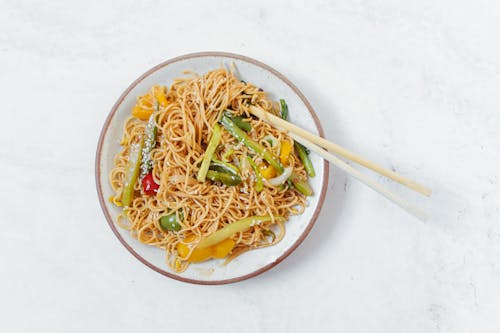 Free Stir-Fried Noodles with Vegetables on White Ceramic Plate Stock Photo