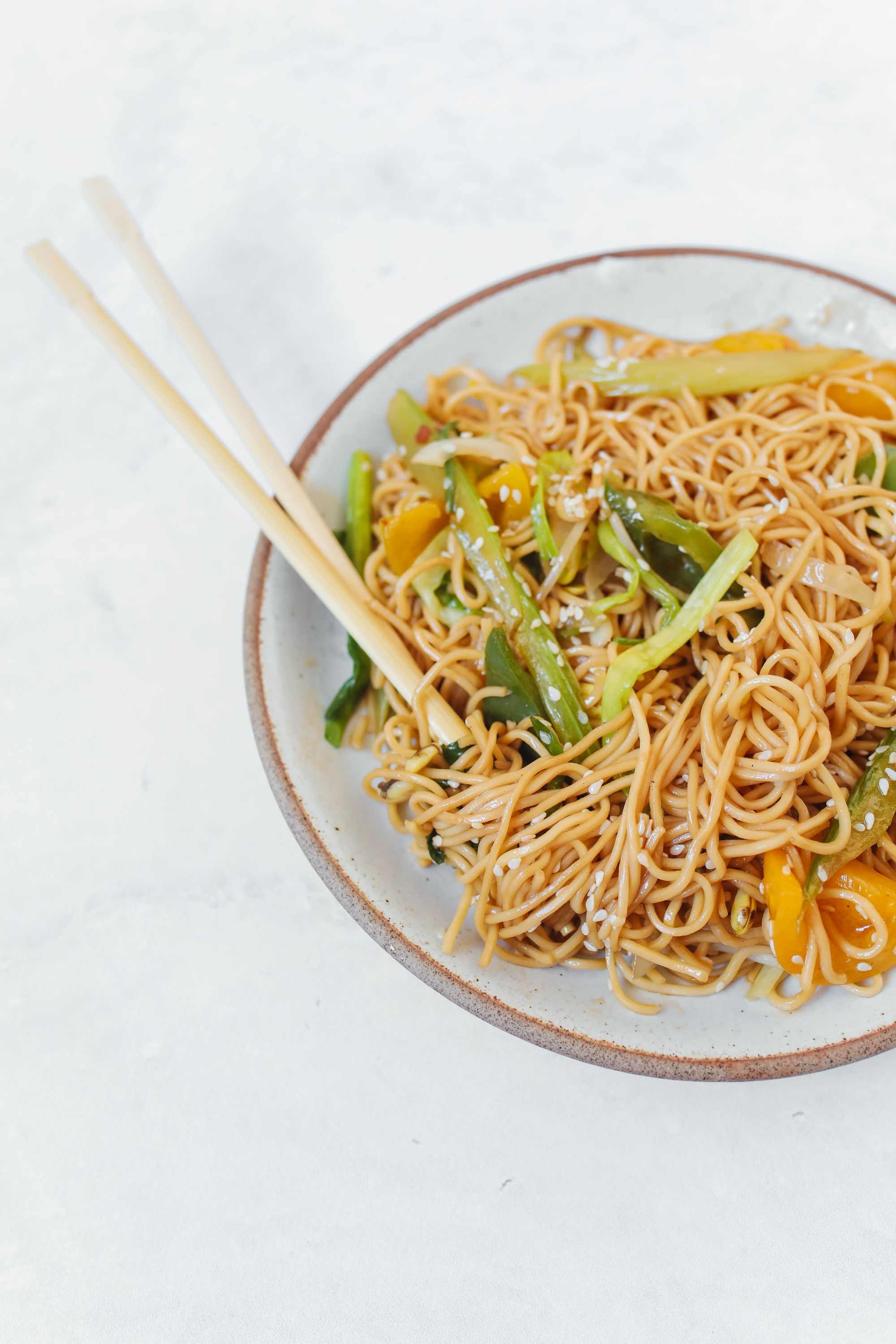 a chinese noodle in the plate with chopsticks