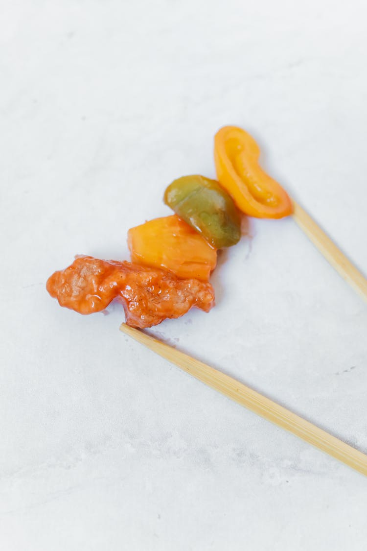 Meat And Vegetable Stir Fry And Chopsticks On A White Surface