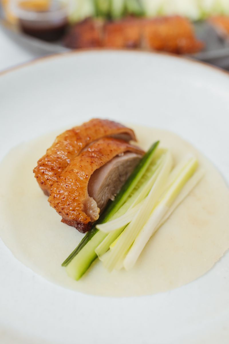 Sliced Peking duck with pancake and garnishes