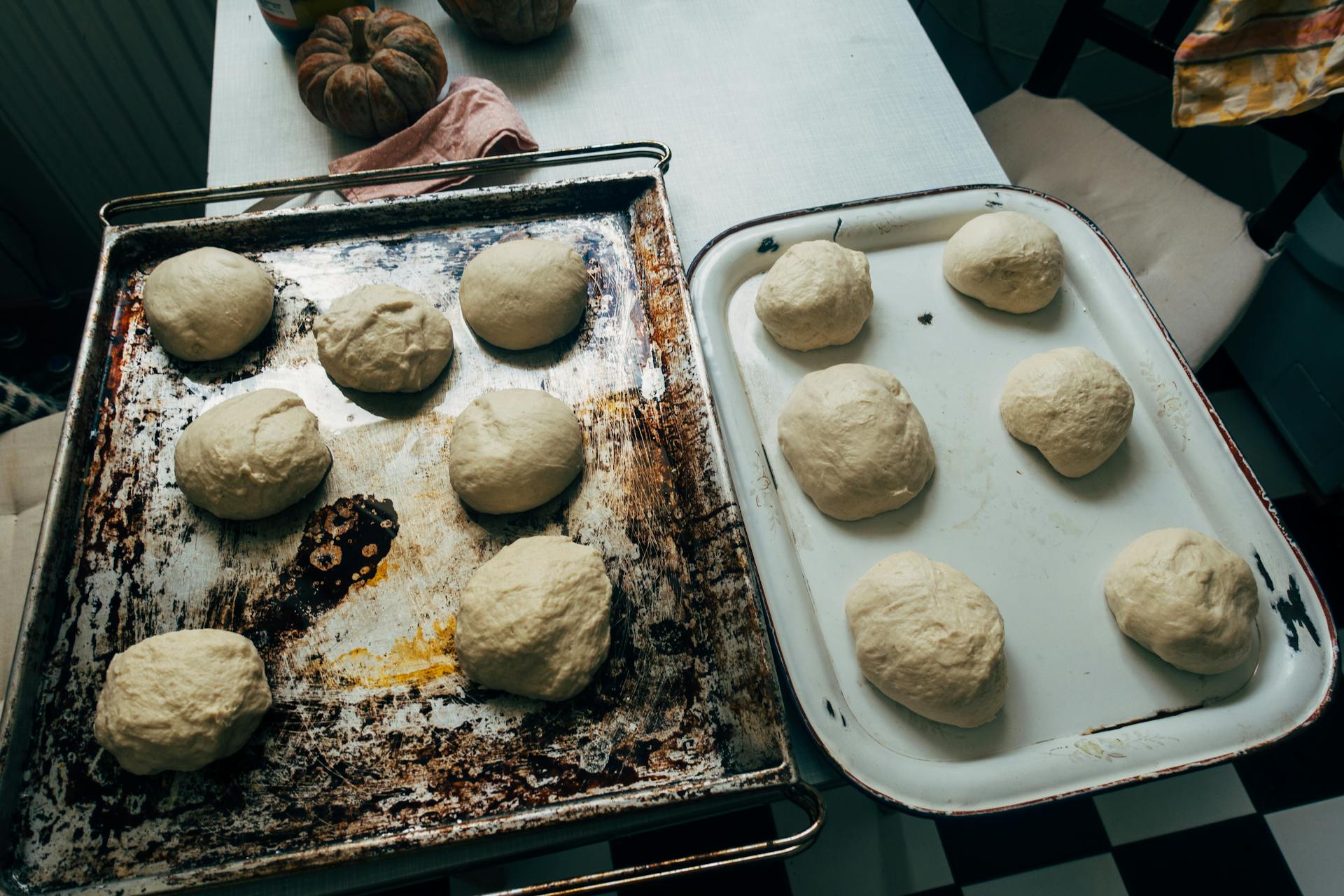 Homemade dough balls rising on rustic trays, ready for baking.