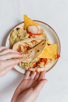 A vibrant plate of tacos with guacamole, topped with nachos and radish, perfect for a Mexican cuisine theme.