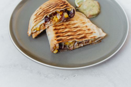 Free Delicious grilled quesadilla with corn, black beans, and guacamole on a gray plate. Stock Photo