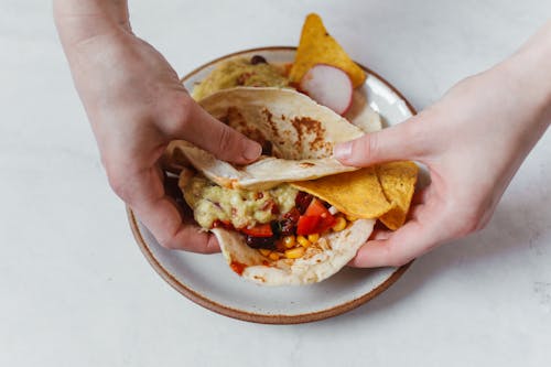 Free Person Holding a Taco with Chips Stock Photo