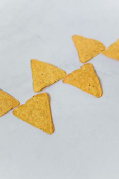 High-quality close-up of crispy tortilla chips, popular Mexican snack, isolated on a white background.