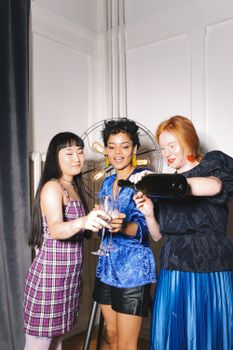 三位性格各异的年轻女性在室内倒香槟庆祝