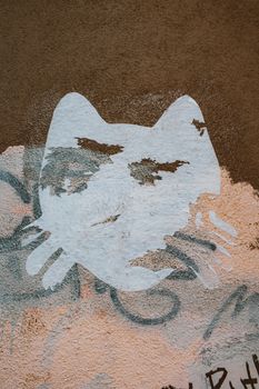 粗糙的城市墙壁上，画着艺术猫涂鸦，展现出抽象的街头艺术风格