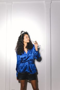 一位穿着蓝色衬衫的女人在室内举杯庆祝新年