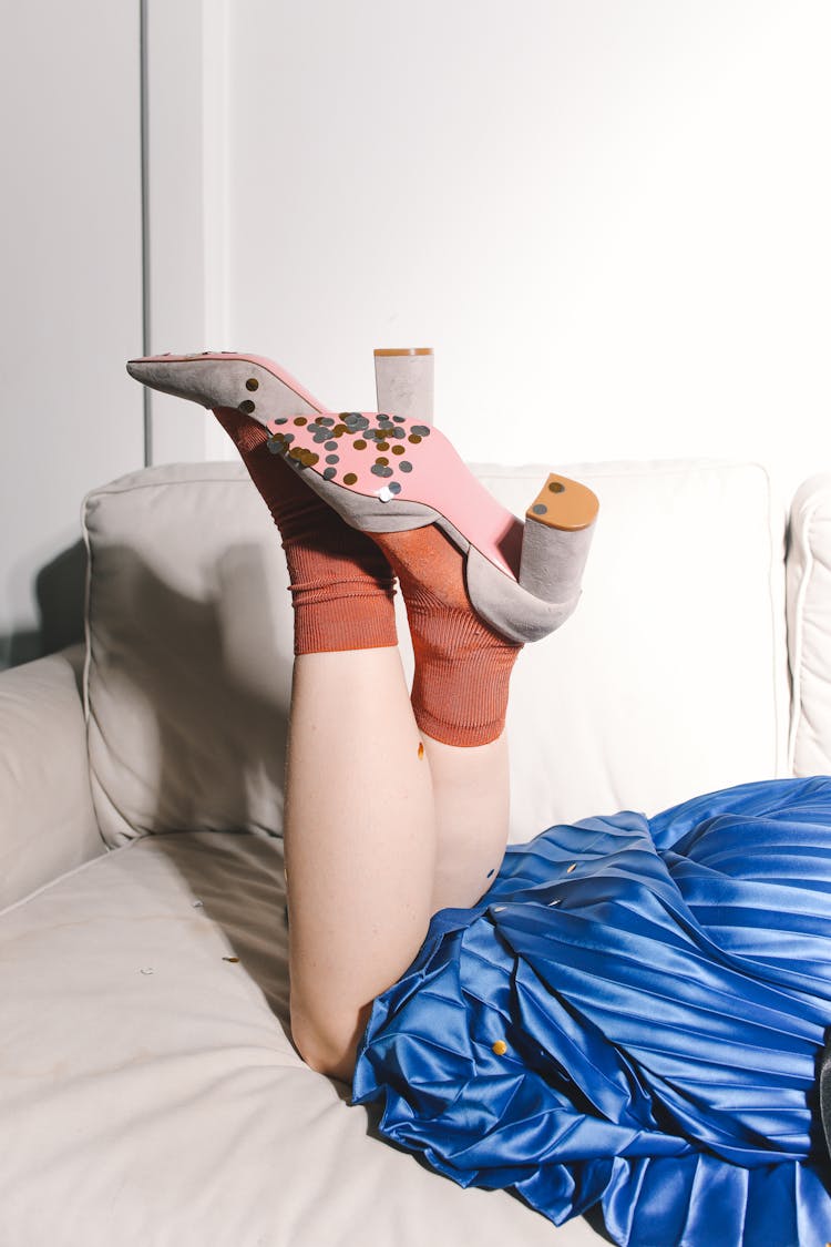 A Person With Confetti On The Bottom Of Their Shoes Laying On A Couch