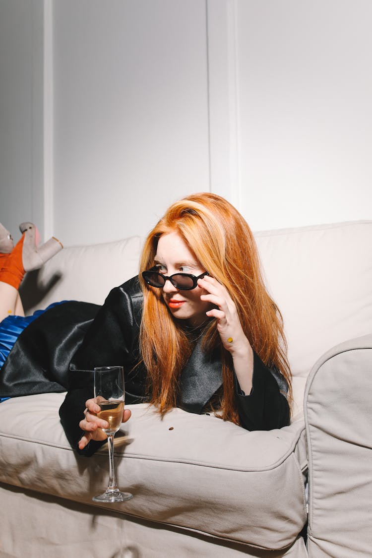 Woman Lying On The Couch Holding A Champagne Glass